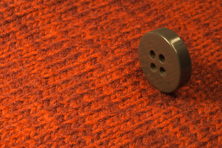 Button on red textile background. macro view. copy space