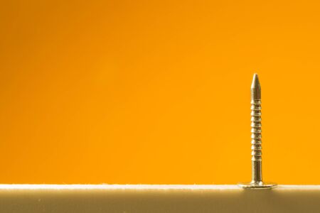 Metal nails isolated on yellow backgroundの写真素材