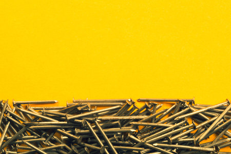Metal nails isolated on yellow background