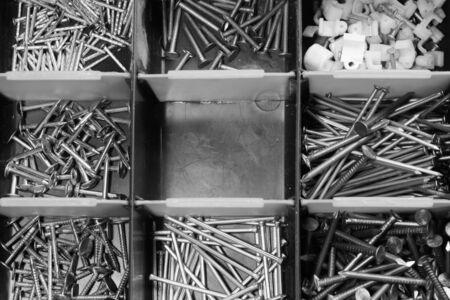 Various metal nails in toolbox background. nails in the cells of the box. copy spaceの写真素材