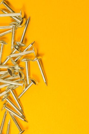 Metal nails isolated on yellow backgroundの写真素材