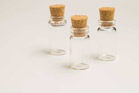 Empty little bottles with cork stopper isolated on white. glass vessels. transparent containers. test tubesの写真素材