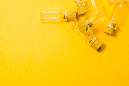 Empty little bottles with cork stopper isolated on yellow. glass vessels. transparent containers....