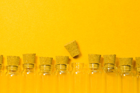 Empty little bottles with cork stopper isolated on yellow. glass vessels. transparent containers....