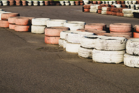 Race track safety barrier. asphalt racing track with red and white tires. colorful tires stack....