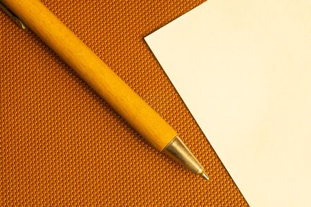 White paper with wooden pen on a brown background. copy spaceの写真素材