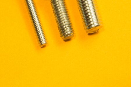 Steel screw on a yellow background. working toolsの写真素材