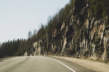 Mountain road. highway in mountains. rocky cliff on the side of roadwayの写真素材