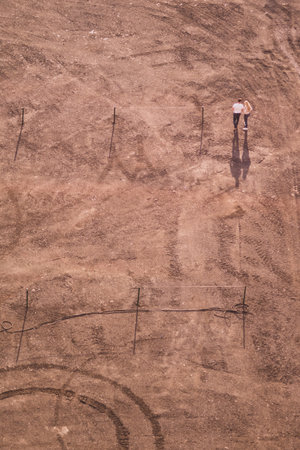 Couple walking on the sand in sunny day. aerial view. ground with tracks and footprints. view from...