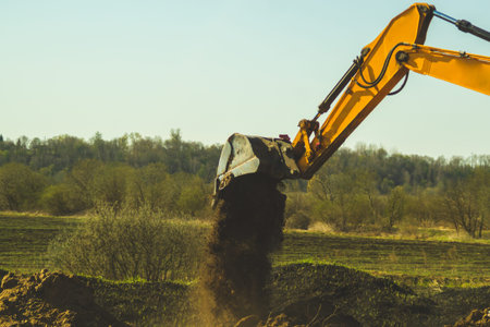 Excavator digs the ground. part of construction earthmoving equipment. digging and filling the soil...