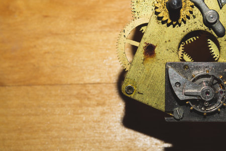 Wooden background with detail of a clock mechanism. gears of a mechanical watch