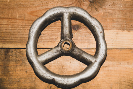 Vintage valve on wooden background. steel wheel valve on the table. industrial background