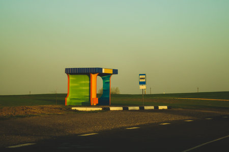 Rural bus stop on the country road with the field. countryside landscape