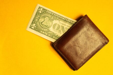 One dollar bill in wallet isolated on yellow backgroundの写真素材