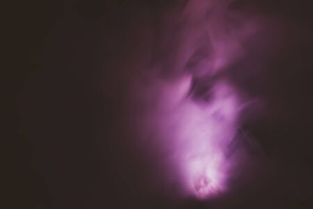 Violet smoke on black backdrop. color fog abstract backgroundの写真素材