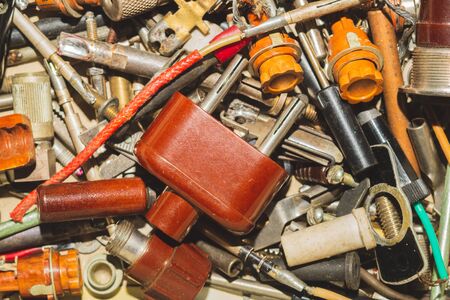 Pile of fasteners and screws close up. scrap metal. different metal parts. classic power plug. industrial backgroundの写真素材