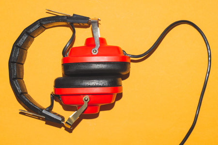 Vintage red headphones on yellow background. retro earphones
