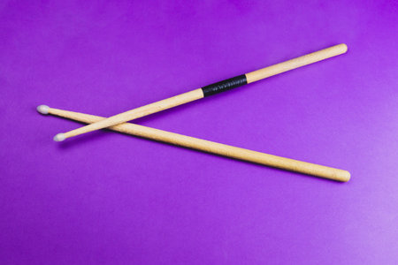 A pair of wooden drumsticks isolated on color background. copy space