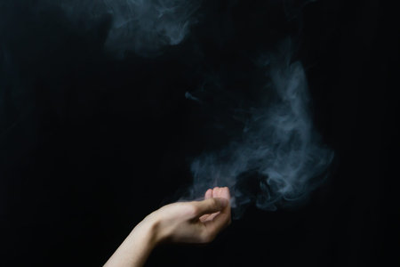 Smoke in hand. abstract fog in the dark. hand creates a magic spell