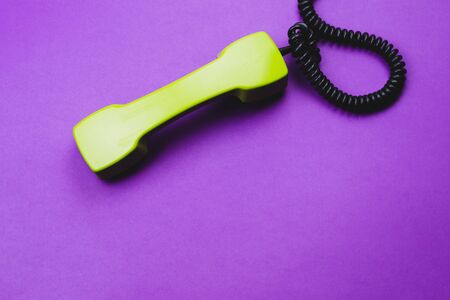 Vintage green telephone handset. phone receiver isolated on purple background. old communication technology. copy spaceの写真素材