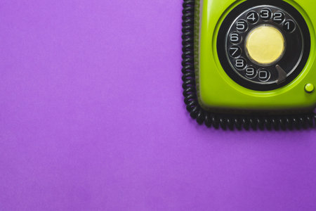 Vintage rotary phone. classic green telephone with round dial. isolated on purple background. old communication technology. copy spaceの写真素材