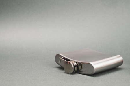 Stainless steel flask lies on the table. personal accessory for alcohol drinks. copy spaceの写真素材
