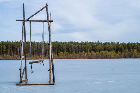 Wooden swing on a frozen lake. solitude concept. nature landscapeの写真素材