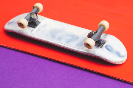 Small skateboard on color background. tiny skate for fingers. fingerboard close up. copy spaceの写真素材