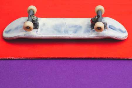 Small skateboard on color background. tiny skate for fingers. fingerboard close up. copy spaceの写真素材