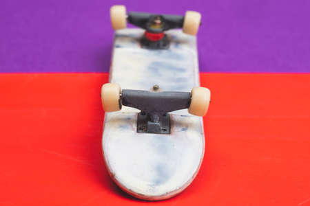 Small skateboard on color background. tiny skate for fingers. fingerboard close up. copy spaceの写真素材