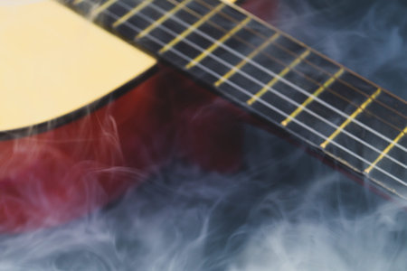 Defocused guitar in smoke abstract background. musical instrument. strings on the guitar fretboard....