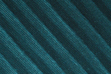 Green textile with parallel folds. fabric texture with flat creases. cloth background close upの写真素材