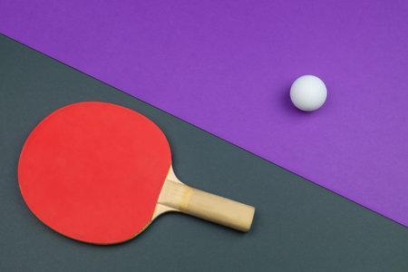 Red table tennis racket with a ball isolated on a colored background. sport equipment