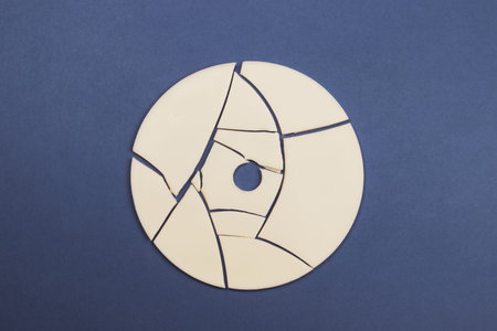 Cracked disc on color background