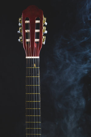 Guitar in smoke on the black background. acoustic musical instrument. strings on the guitar neck