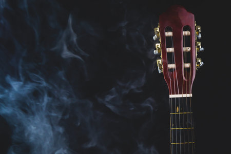 Guitar in smoke on the black background. acoustic musical instrument. strings on the guitar neck