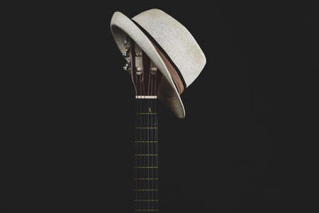 White hat hangs on the guitar fretboard. acoustic musical instrument. strings on the guitar neck close upの写真素材