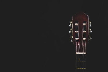 Guitar headstock on black background. acoustic musical instrument. copy space