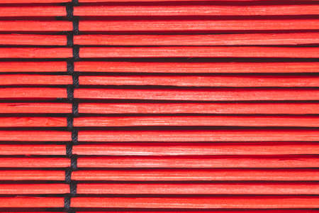 Bamboo mat background close up. wooden backdrop. red wooden sticks bound togetherの写真素材