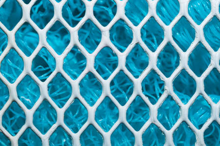 Metal enameled grid. abstract background. blue cloth behind the metallic grate. iron white meshの写真素材