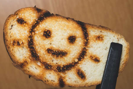 Toasted bread with smiling sun picture. symbol on the toastの写真素材