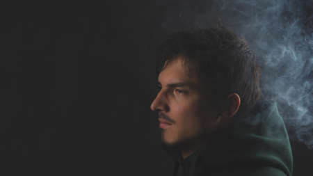 Young man on the black background. male portraitの写真素材