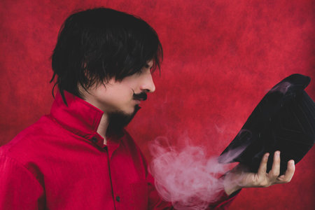 Man with hat in red shirt on the red background. male portrait