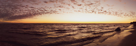 Golden sunset over the sea with sand beach. sky with clouds at the evening. panoramic view