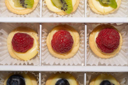 Mini cakes with raspberry close up. delicious small tarts macroの写真素材