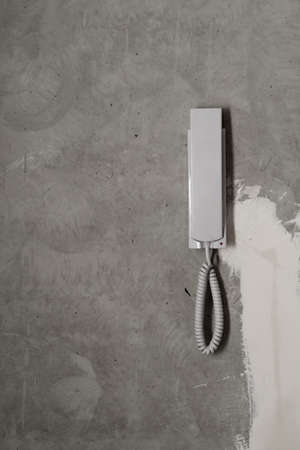Intercom phone receiver on gray concrete background. handset on the wall close upの写真素材