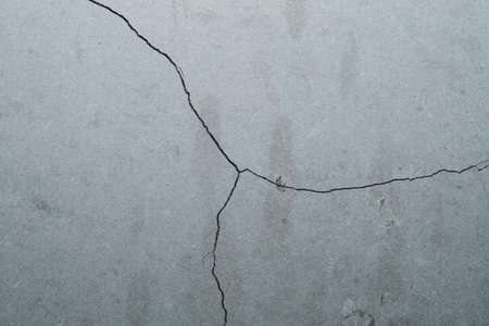 Concrete wall with cracks and scratches. abstract gray background with patterns. wall is ready for renovation worksの写真素材