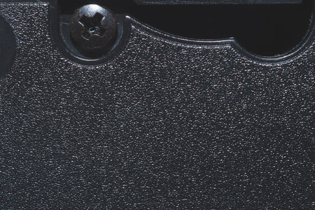 Black plastic surface with screw. detail of plastic cassette