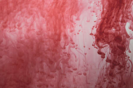 Red ink in the water abstract background. splashes of paint in liquidの写真素材