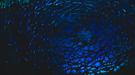 Shattered transparent glass pattern in the dark. abstract cracked background. blue splintersの写真素材